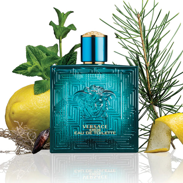 Versace Eros Eau de Toilette bottle with green leaves and a lemon on a white background