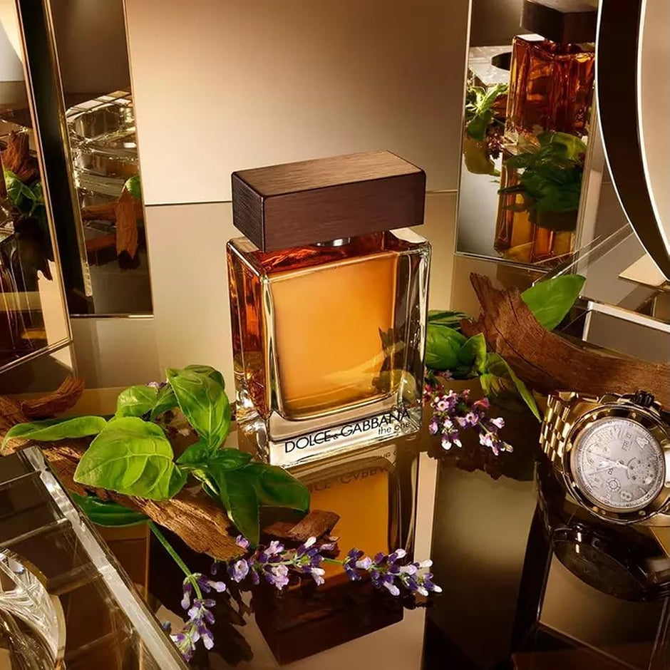 Dolce & Gabbana perfume bottle on a decorative surface with plants and a watch.