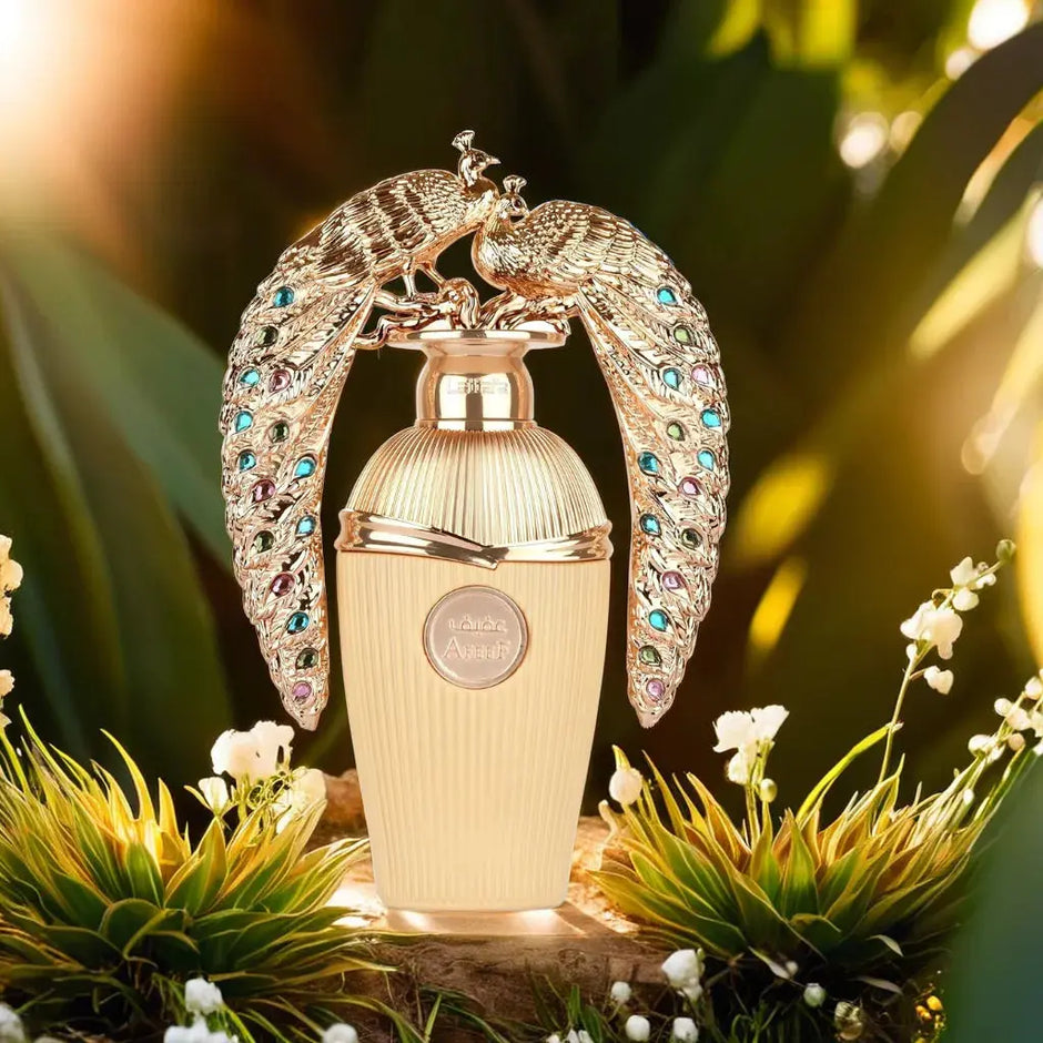 Decorative perfume bottle with peacock design on a natural background