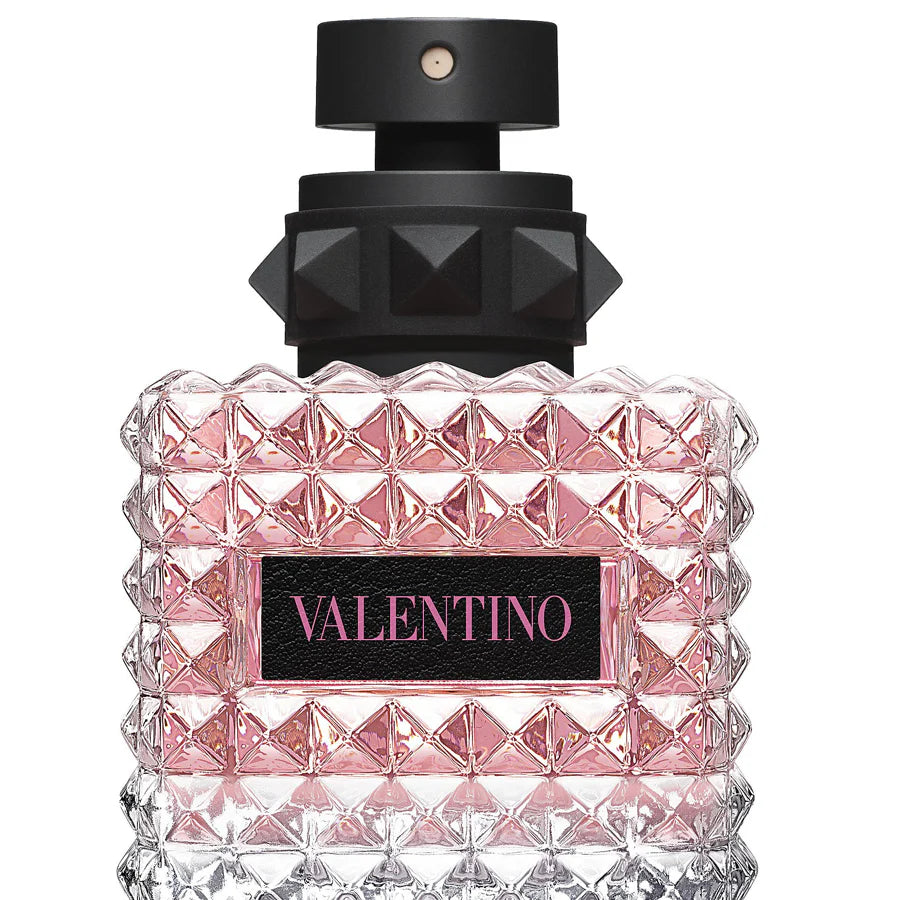 Valentino perfume bottle with pink diamond pattern and black cap on a white background