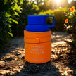 Orange thermos with blue lid on a natural background