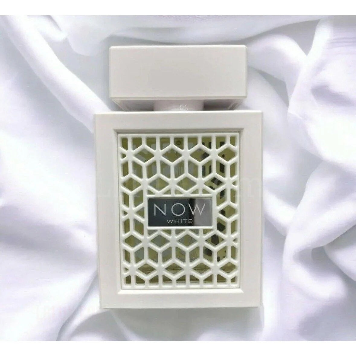 White perfume bottle with geometric design on a white background