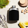 Montblanc black perfume bottle on a textured surface with natural elements like lavender and lemon slices.