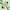 Prada shoes and triangular perfume bottles on a light green background