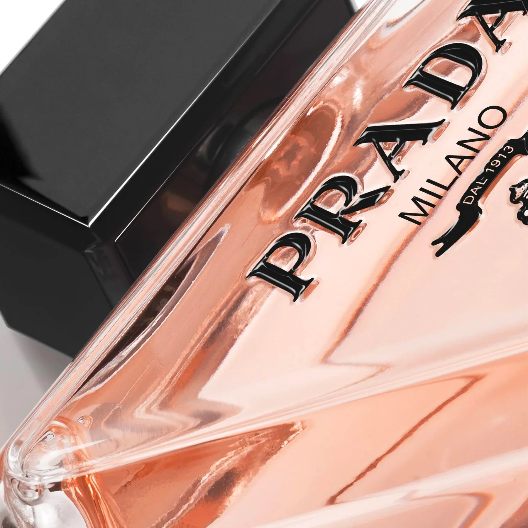 Close-up of a Prada perfume bottle with a clear cap.