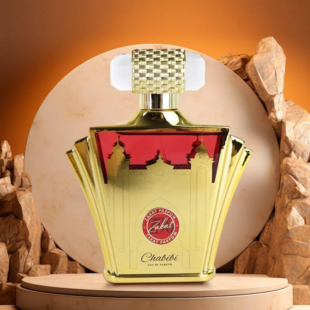 Gold and red perfume bottle with 'Zahab' branding on a stone background. Perfume