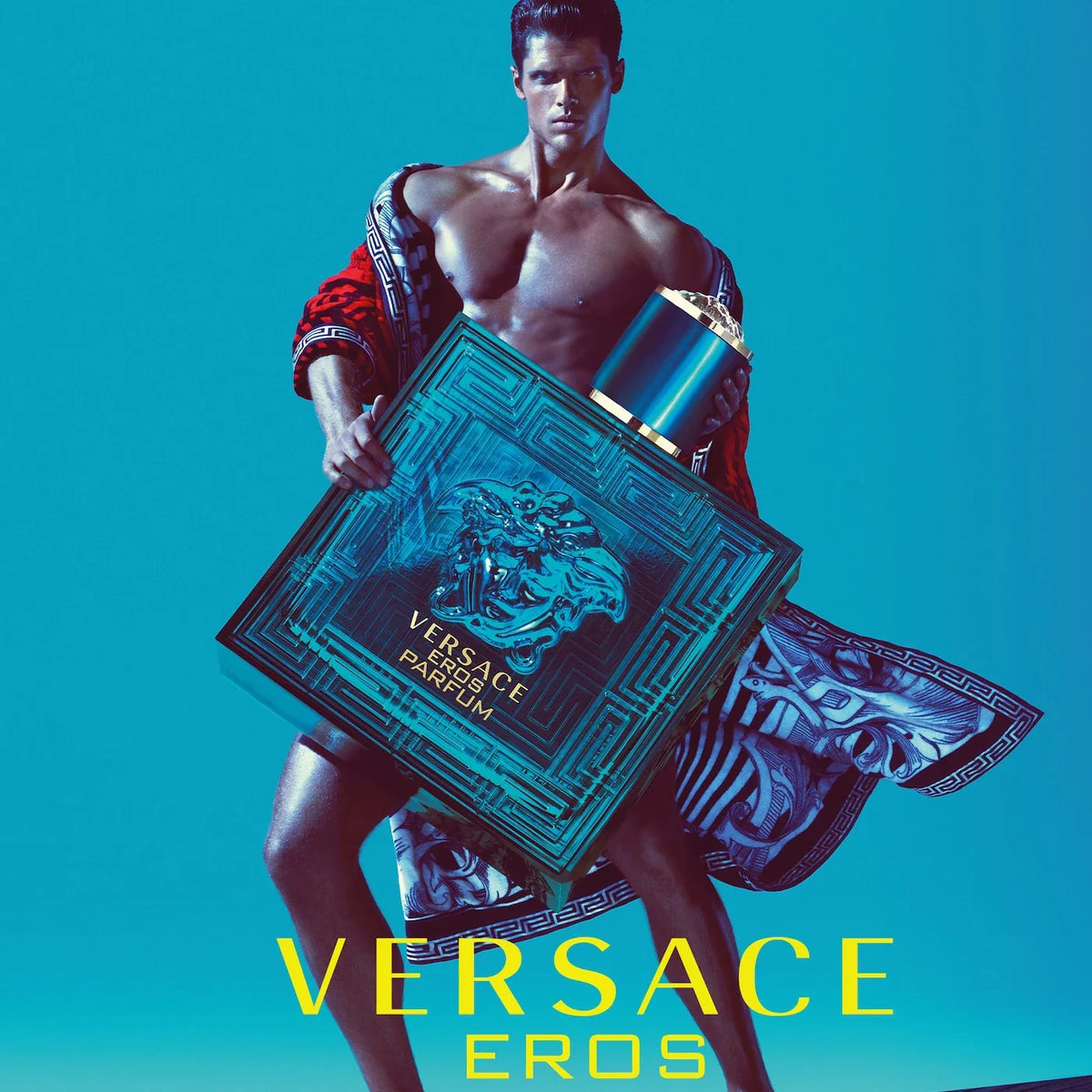 Man holding a Versace Eros perfume box against a blue background